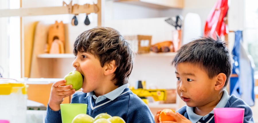 Child eating an apple in nursery